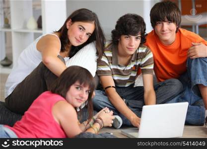 teenagers having fun with a laptop at home