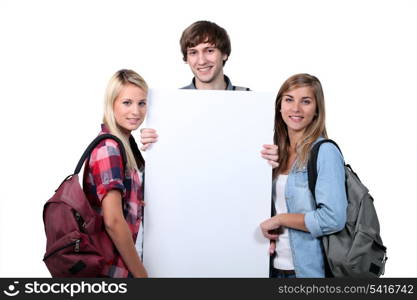 Teenagers holding up poster