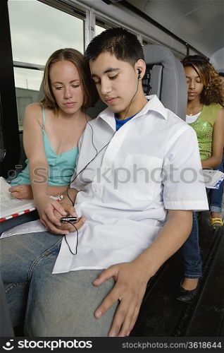 Teenagers Listening to MP3 Player While Riding School Bus