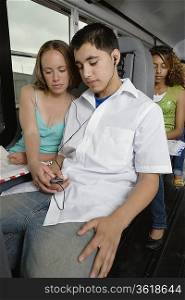 Teenagers Listening to MP3 Player While Riding School Bus