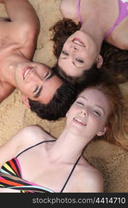 Teenagers lying on the sand