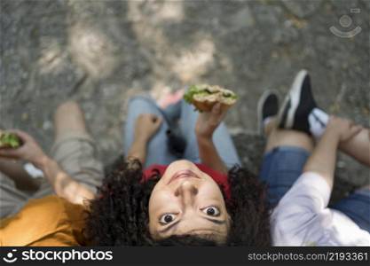 teenagers outdoors together enjoying burger