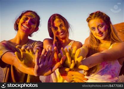 Teenagers playing with colored powder and showing her hands