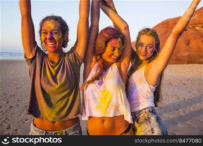 Teenagers playing with colored powder on the beach