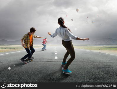 Teenagers ride skateboard. Active teenagers riding skateboard on asphalt road