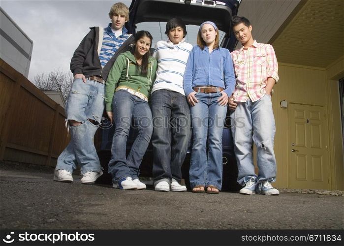 Teenagers standing in front of a car