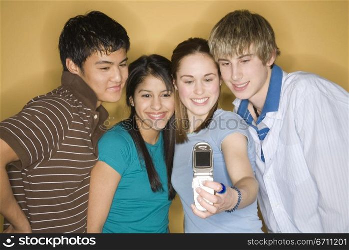 Teenagers taking a photograph of themselves on a mobile phone