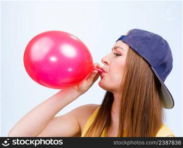 Teens and parties. Preparation for celebration. Trendy teenage girl blowing red balloon. Young beauty woman prepare accessories for party.. Teen girl blowing red balloon.