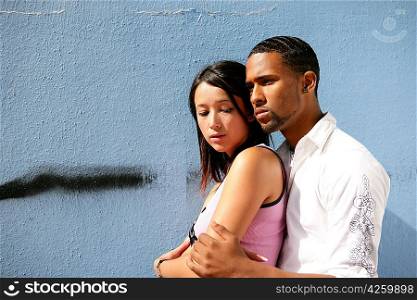 Teens embracing in front of a wall