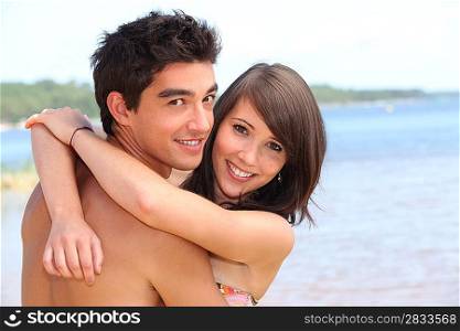 Teens embracing on the beach