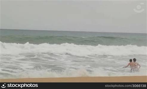 Teens enjoying the waves in slow motion