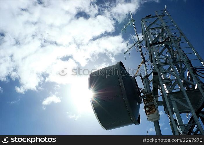 Telecommunication tower in back-light against a cloudy blue sky