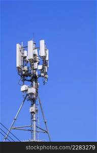 Telecommunication tower with antenna and equipment for cellular communication system against blue clear sky in vertical frame