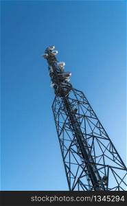 Telecommunications tower against blue sky. Communication concept