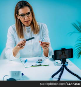 Telehealth ? Medical doctor recording video instructions for patient and demonstrating how to use blood sugar lancet