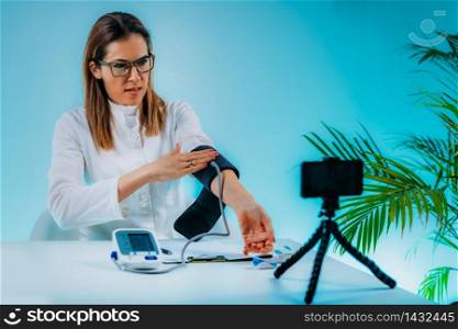 Telehealth ? Medical doctor recording video instructions for patient and demonstrating how to measure blood sugar