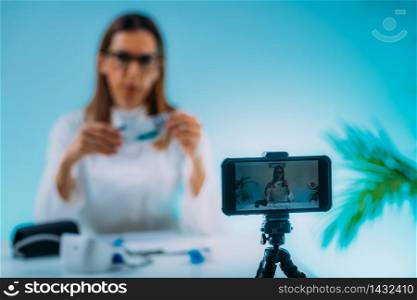 Telehealth ? Medical doctor recording video instructions for patient. Showing medication for therapy