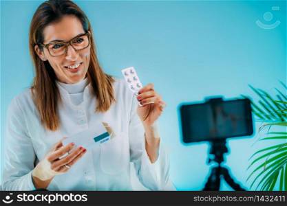 Telehealth ? Medical doctor recording video instructions for patient. Showing medication for therapy