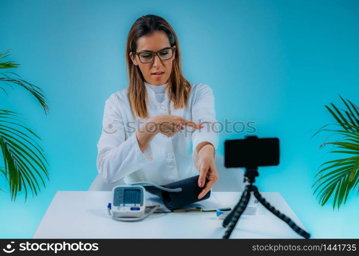 Telemedicine ? Medical doctor having a virtual conference session with patient and demonstrating how to measure blood pressure . Telemedicine ? Medical doctor having a virtual conference session with patient and demonstrating how to measure blood pressure