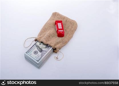 Telephone booth and banknote bundle of US dollar in a sack