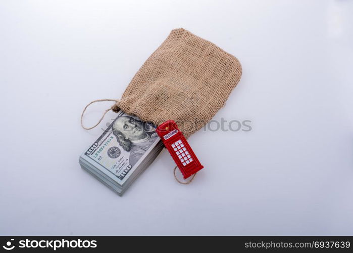 Telephone booth and banknote bundle of US dollar in a sack