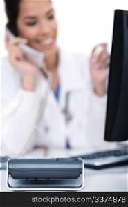 Telephone of focus, doctor talking with it over white background