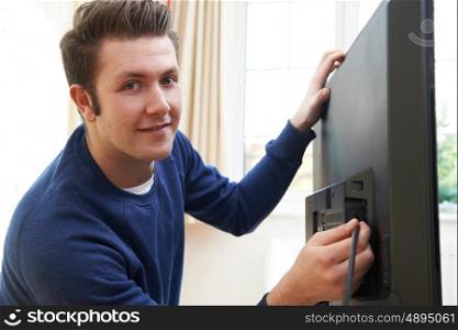 Television Engineer Installing New Television At Home