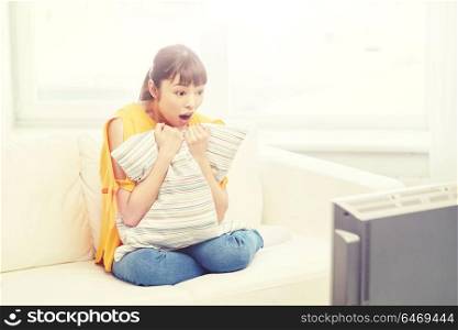 television, leisure and people concept - asian young woman watching tv at home. asian young woman watching tv at home