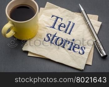 Tell stories advice or reminder - handwriting on a napkin with cup of coffee against gray slate stone background