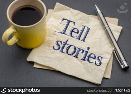 Tell stories advice or reminder - handwriting on a napkin with cup of coffee against gray slate stone background