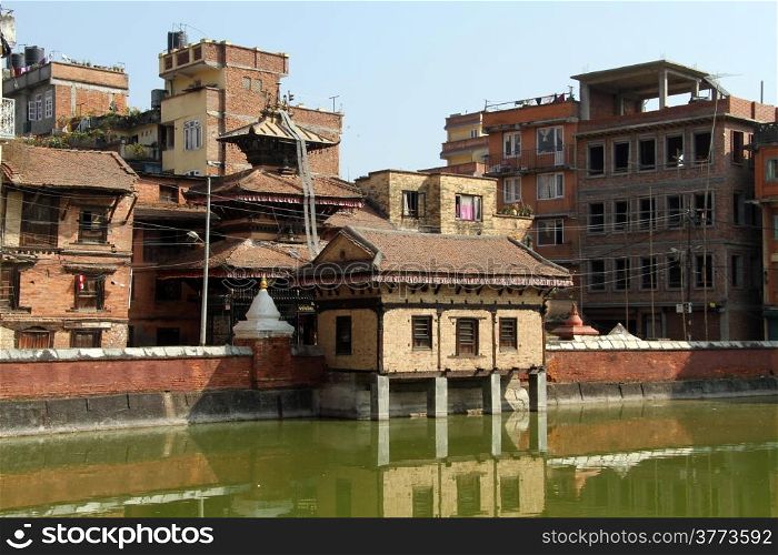 Temple and buildings near green pond in Patan, Nepal