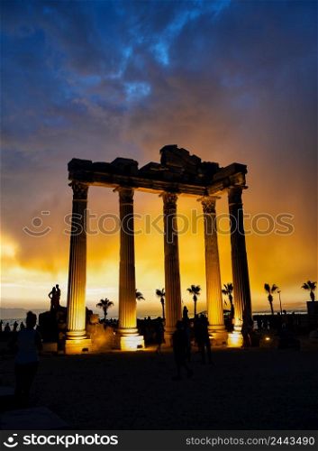 Temple of Apollo in Side at sunset. Silhouettes of people. Architectural heritage. A popular tourist destination. One of the main attractions of Turkey. Temple of Apollo in Side at sunset