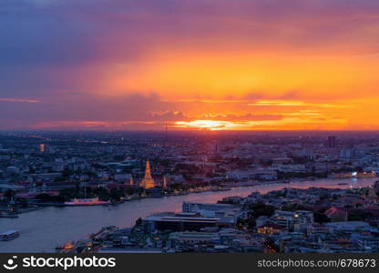 Temple of Dawn, Wat Pho Temple with buildings and curve of Chao Phraya River. Urban city, Downtown Bangkok at sunset, Thailand.