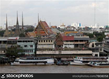 Temples and boats on the river Chao Phraya in Bangkok, Thailand