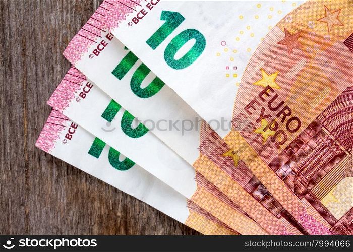 Ten euros notes laid on the wooden background