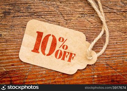 ten percent off discount - a paper price tag against rustic red painted barn wood