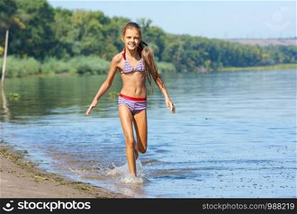 Ten year old girl runs along the river