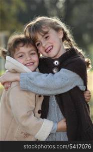 tender scene of two little girls hugging