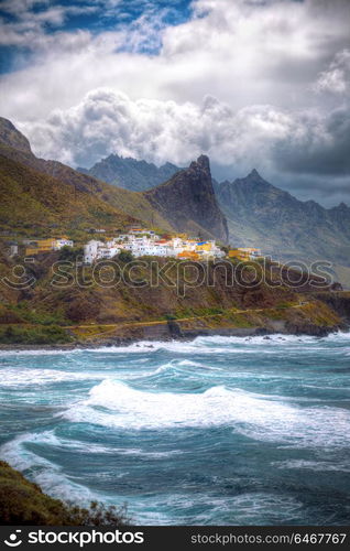 Tenerife island. On the cliff is a village at the bottom of the raging ocean