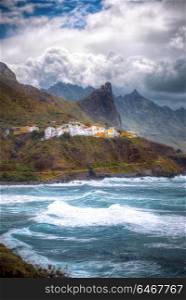 Tenerife island. On the cliff is a village at the bottom of the raging ocean
