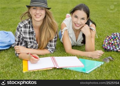 Tennage students lying on the grass and study together