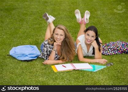 Tennage students lying on the grass and study together