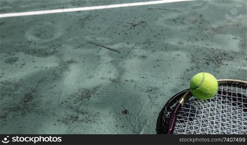 Tennis ball and racket in outdoor tropical court. Tennis ball and racket in the court