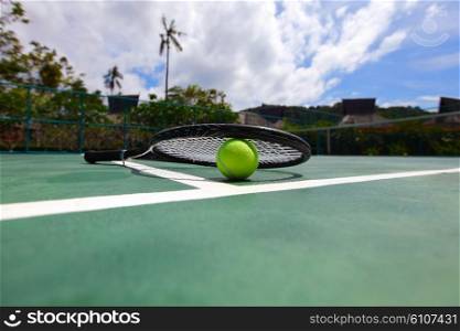 Tennis ball and racket . Tennis ball and racket on court close up