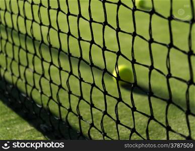 tennis ball behind the net in sunny day in May