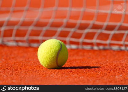 Tennis ball on a court near a sport net