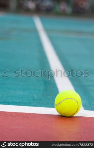 Tennis ball on the field. Tennis ball resting on a golf ball.