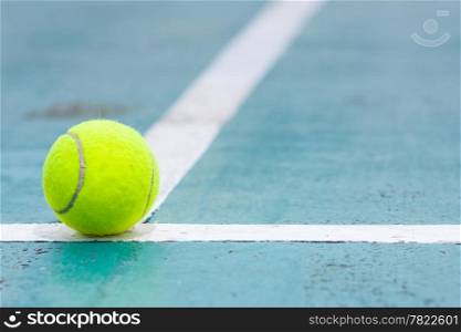Tennis ball on the field. Tennis ball resting on a golf ball.