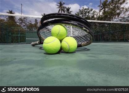 Tennis balls and racket . Tennis balls and racket on court close up