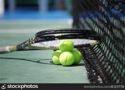 Tennis balls and racket . Tennis balls and racket on court close up
